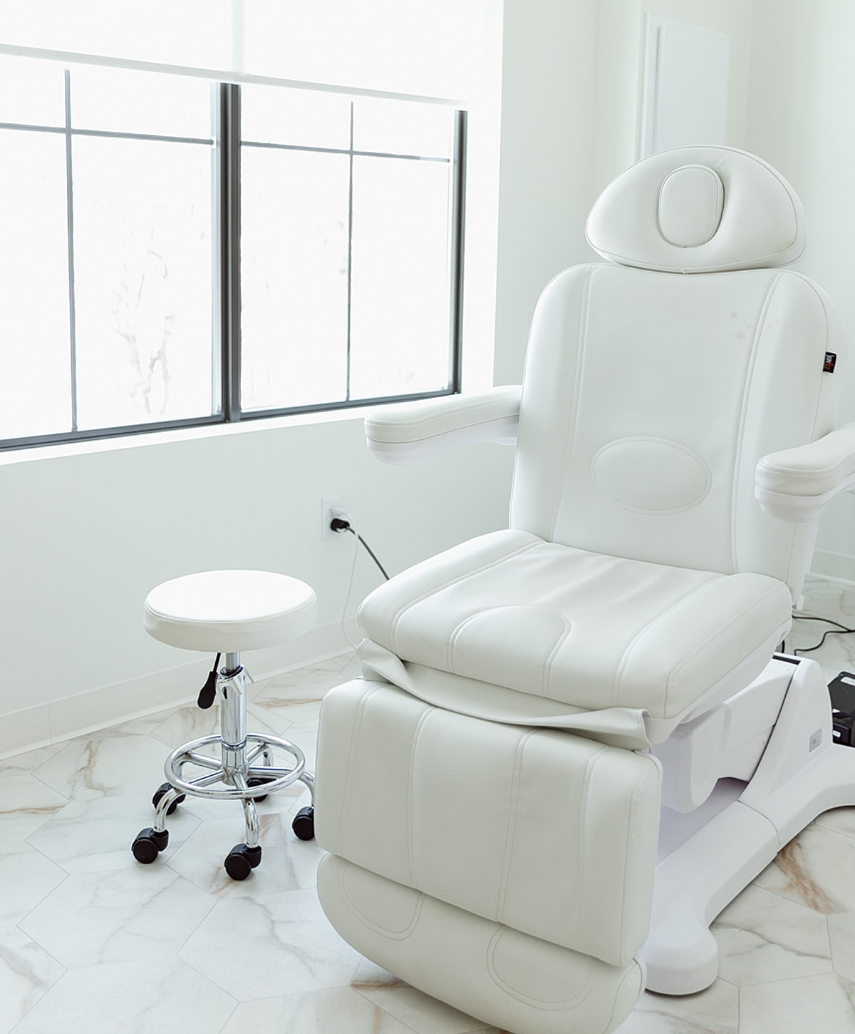 Modern white aesthetic massage chair in bright room.