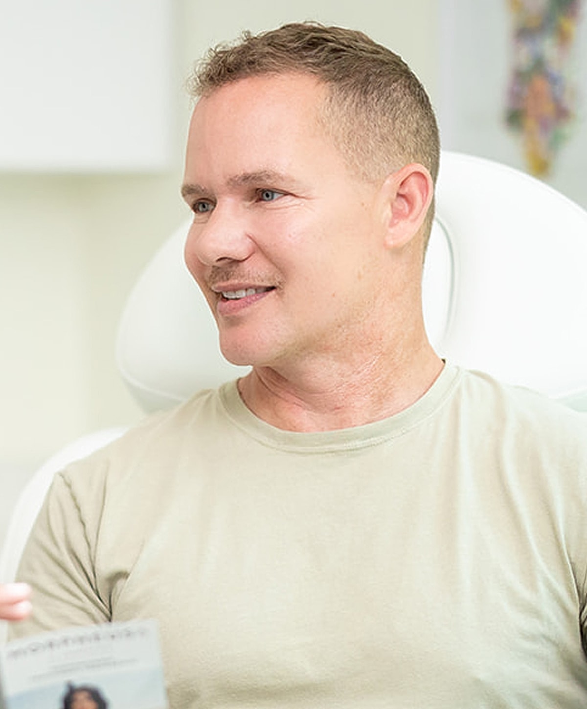 Man smiling during a conversation in a clinic.
