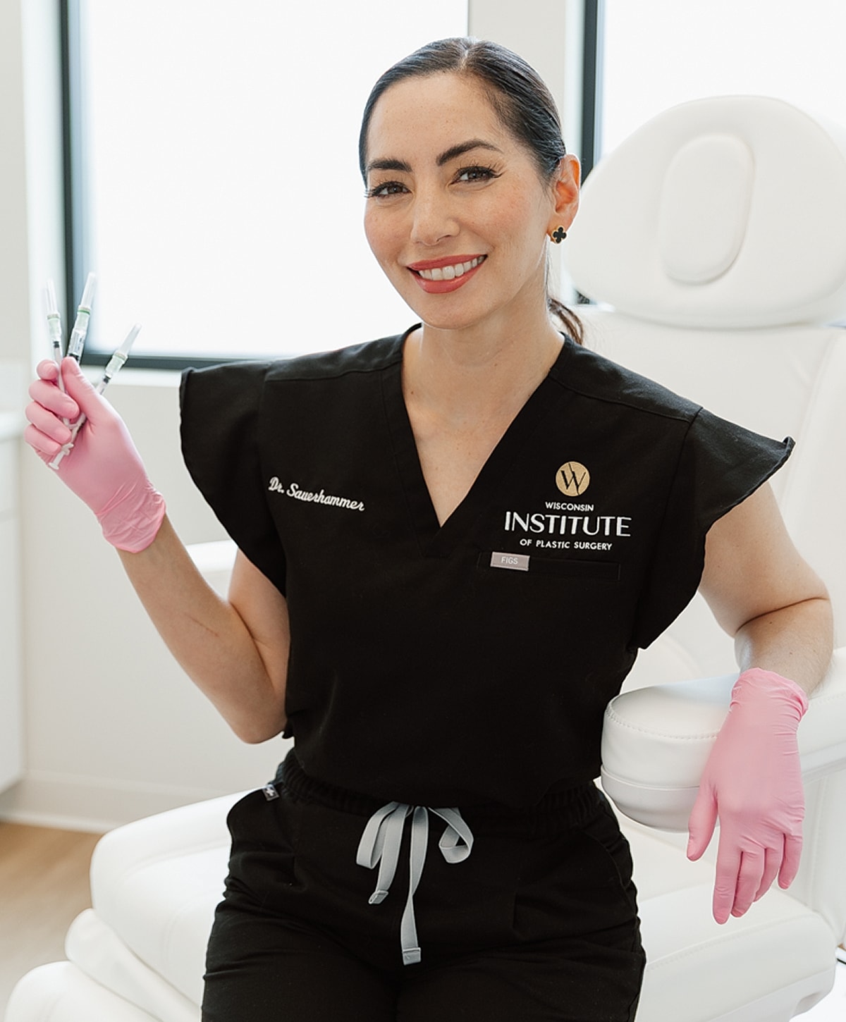 Doctor holding syringes in a medical setting.