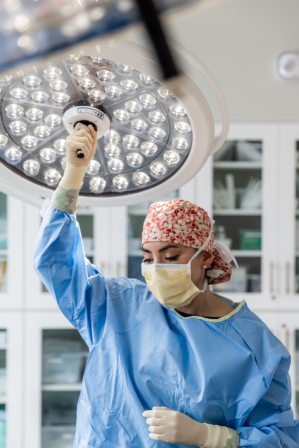 Surgeon adjusting operating room light equipment.